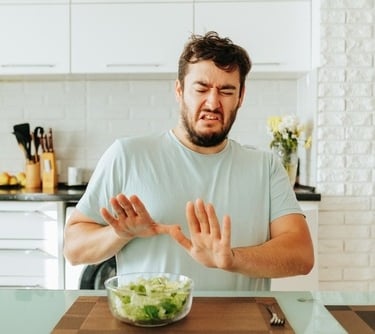 a man with a bowl of salad on a cutting board