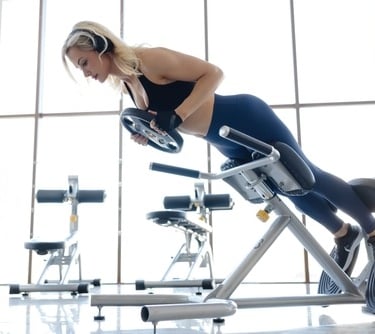 a woman in a sports bra top and headphones on a stationary bench