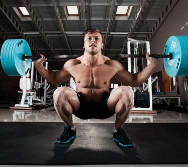 a man squatting a barbell in a gym