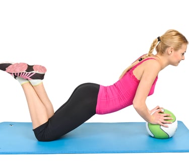 a woman is doing a push-up on a ball