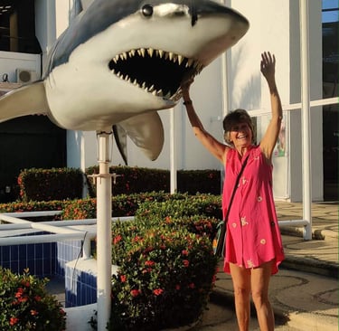 Sara the Author reaching up to spin the shark at Ixtapa Palace Resort Hotel