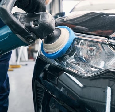 a person polishing a car's headlight