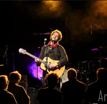 Dorian Chamoin playing guitar in a concert