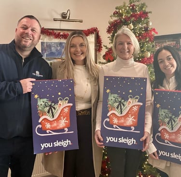 a group of people standing around a christmas tree