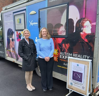 Two women standing in front of a Dementia Experience bus