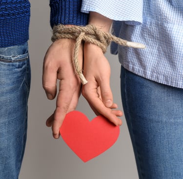 a mão de um homem e a mão de uma mulher estao amarradas segurando um coração