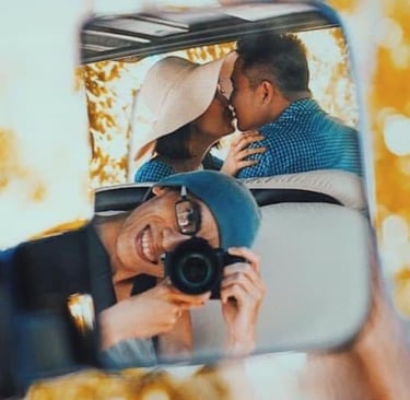 a man and woman kissing in a car mirror