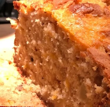apple cheddar bread with one slice on cutting board