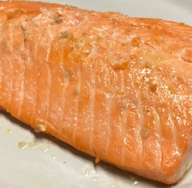 buttery lemon garlic steelhead trout on a white and red plate