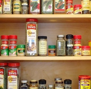 a large variety of spices in the kitchen cabinet.