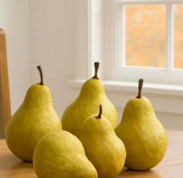 Five ripe Bartlett pears on a wooden kitchen table, with soft autumn light streaming through a window and fall foliage