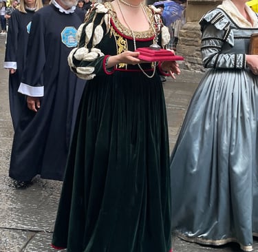 3 people in medieval dress in a procession