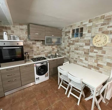 una cucina con tavolo, sedie e orologio