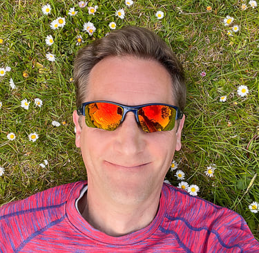 Marcus lying on grass with daisies