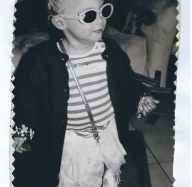 Black and white photo of young girl in extravagant fancy dress
