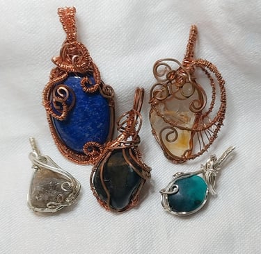a group of five wire wrapped pendants with a blue and green stone pendant.
