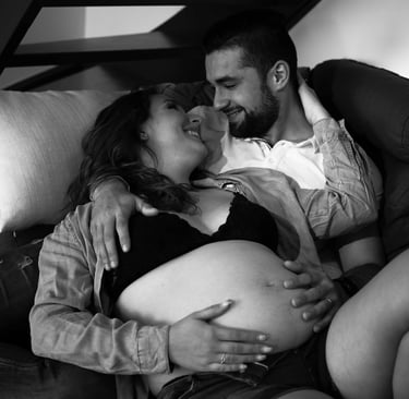 couple se regardant étendu sur le canapé pour une photo de grossesse