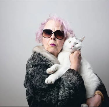femme agée serrant contre elle son chat blanc avec son manteau de fourrure et portant des lunettes d