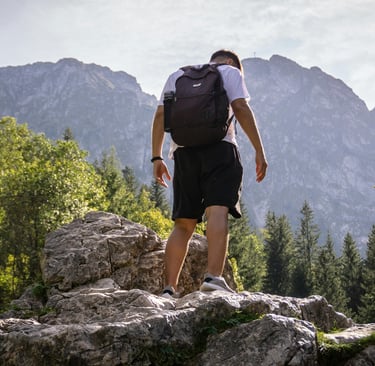 a man with a backpack on a rocky cliff. he is trying to keep himself healthy II