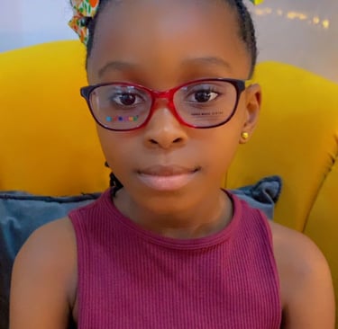a young girl wearing glasses and a pink top