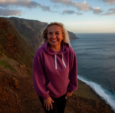 Woman in purple hoodie at dramatic Madeira sunset location