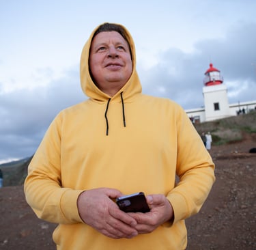 Man in yellow hoodie at Ponta do Pargo lighthouse viewpoint