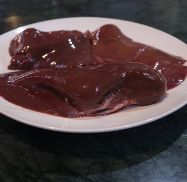 a plate of liver with a piece of meat on it