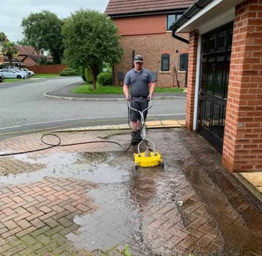 a man is using a pressurer to clean a driveway