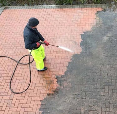 a man in yellow raincoats is using a pressurer