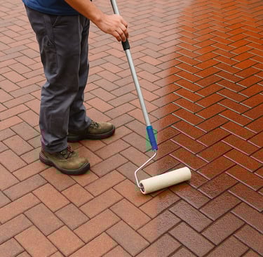 a man is painting a brick wall with a roller roller