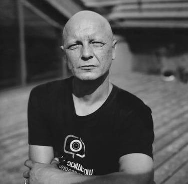 Bald man with black t-shirt looking at camera