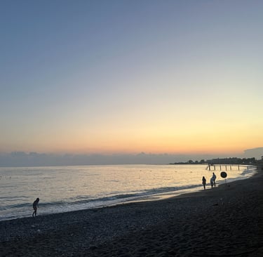 a beach with people walking on the sand