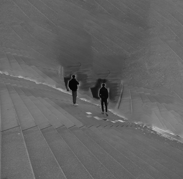 two people standing next to the beach