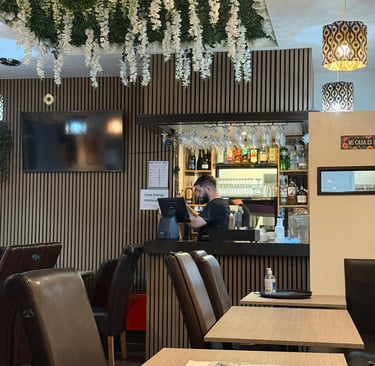 a restaurant with a bar and man  crafting a drink in a bar