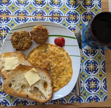 An Indian Omelet with toasted bread with butter and veg cutlet with some ketchup and a cup of coffee