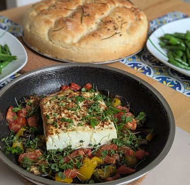 A nice brown Baked Feta Cheese with colorful veggies, topped with Chia microgreens with a crusty Rosemary Bread side dish