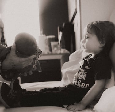 Big Brother getting ready to hold baby brother for the first time