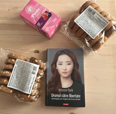 Cartea 'Drumul către libertate' de Yeonmi Park pe o masa cu ceai si fursecuri