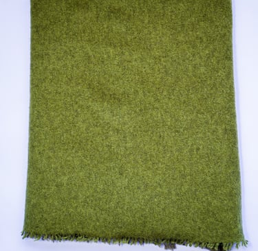 Dark green yak wolle shawl neatly folded on white background, showing soft wool texture and edges.