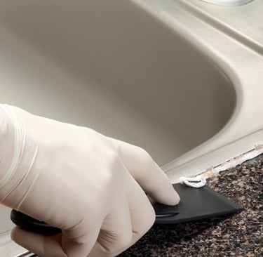 Verwijderen van oude kit langs wasbak tijdens renovatiewerk