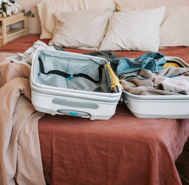 Valigia aperta sul letto con vestiti pronti, per la checklist prima di partire da soli dopo i 60 ann