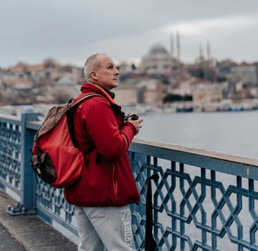 Uomo maturo con zaino osserva una città durante un viaggio da solo.