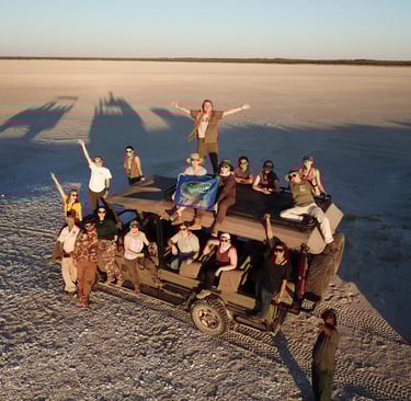 Students waiving during a sundowner on the Salt Pans