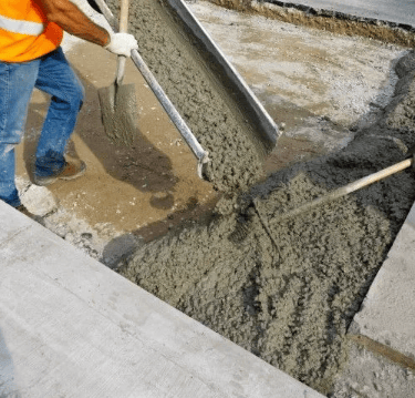 a man is laying concrete on the sidewalk