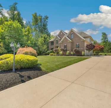 a house with a  concrete driveway and garden