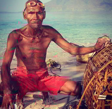 an older alor man with freediving goggles and his fishing cage made of bamboo
