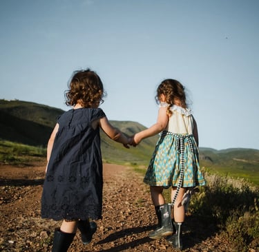 two girls helping each other while wlaking hand in hand