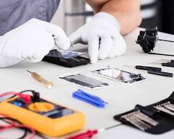 um homem de camisa branca e luvas está trabalhando em um telefone celular