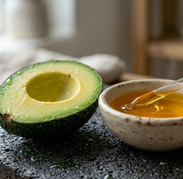 S&B El Artesanal Agacate cortado a lado de un tazón con aceite de aguacate en piedra