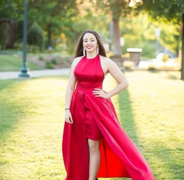 a woman in a red dress standing in the grass